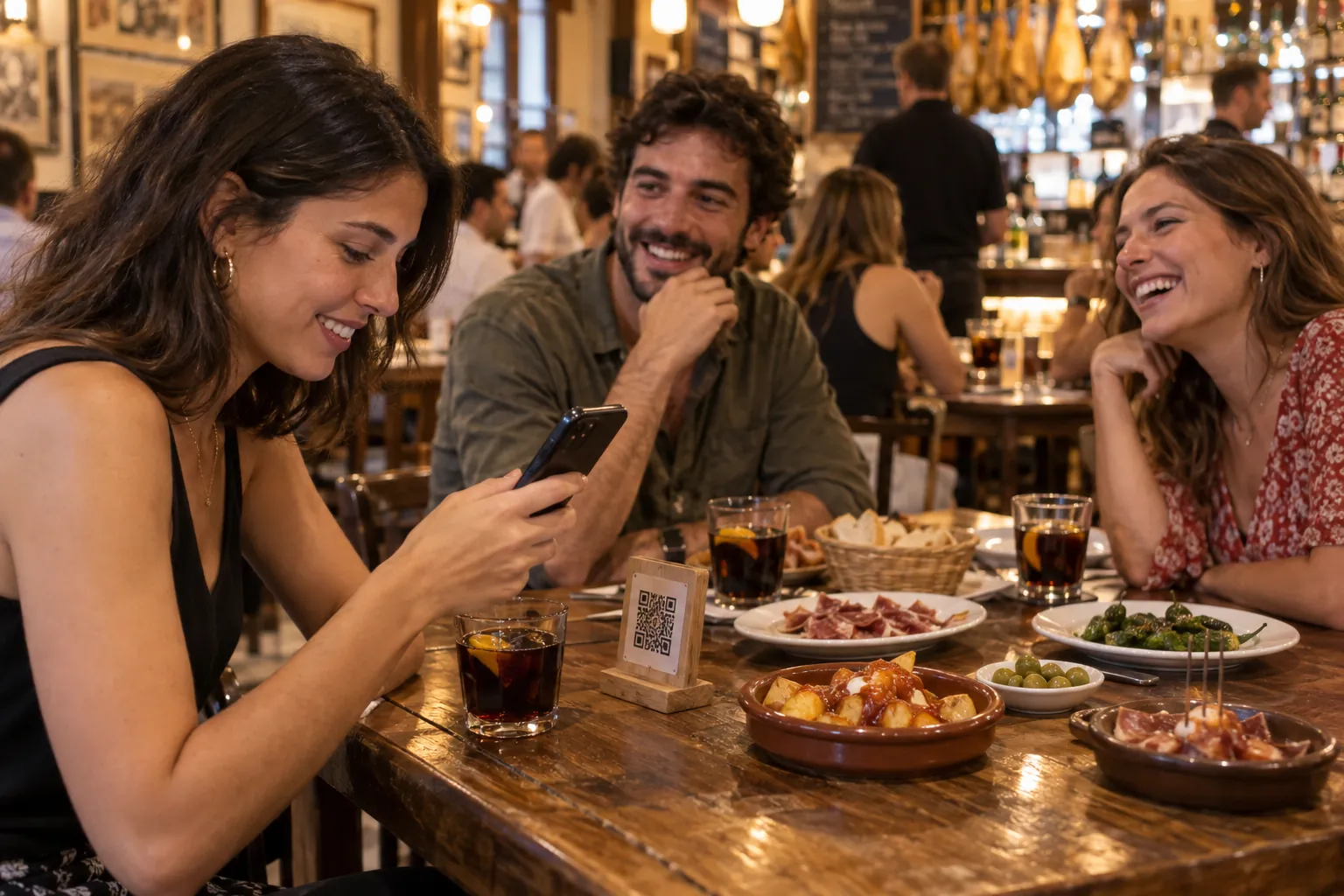 Friends in a tapas bar scan the menu QR code with a phone